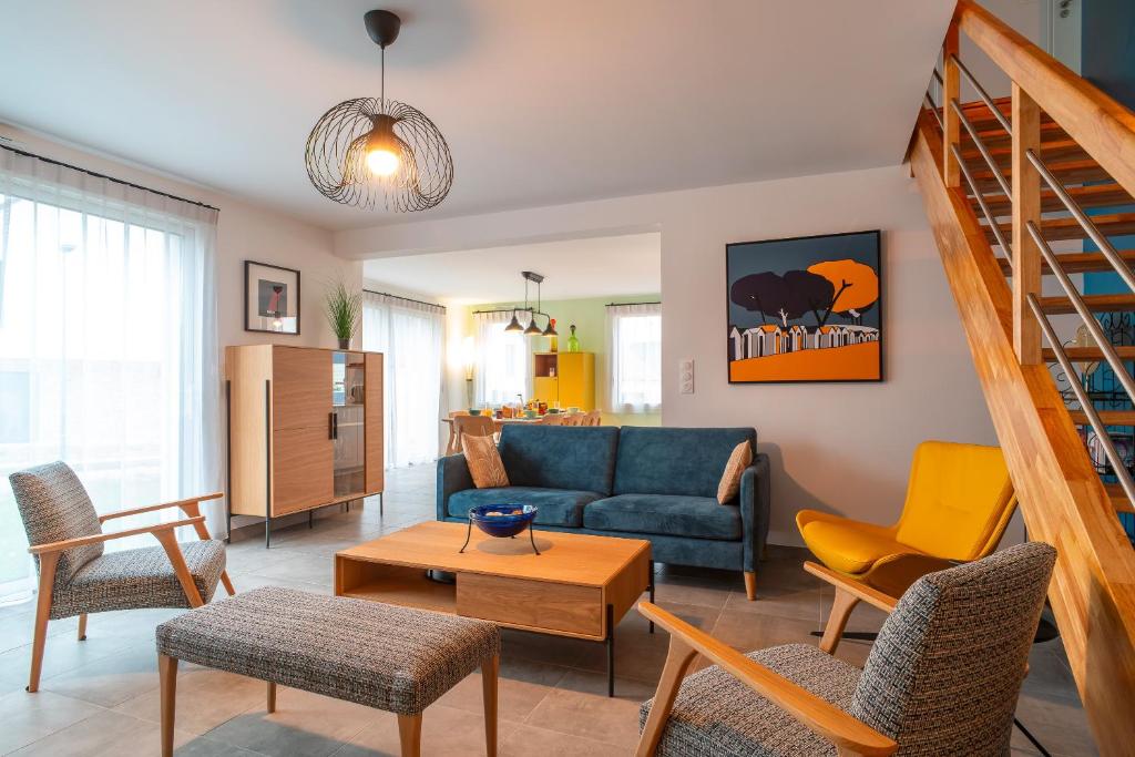 a living room with a blue couch and chairs at Ty Melen Glaz - 200m de la plage in Bénodet