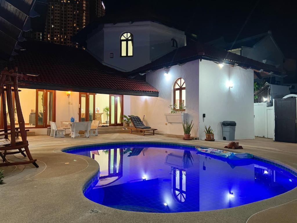 a swimming pool in front of a house at night at Pattaya Beach Pool Villa At Pattaya in Pattaya South