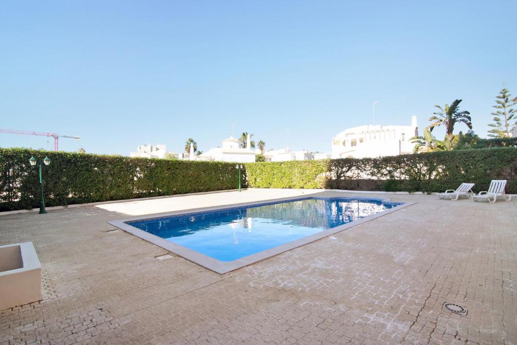 a swimming pool in the middle of a patio at 17f arcos in Armação de Pêra