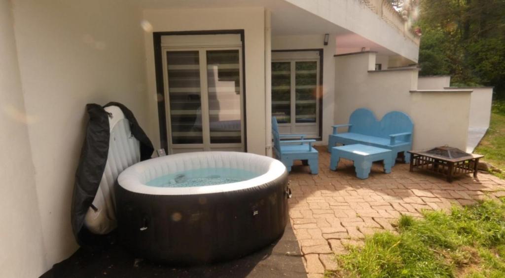 a large bath tub sitting outside of a house at Domaine Moulin Blanc - Gîte Hermine in Meslan