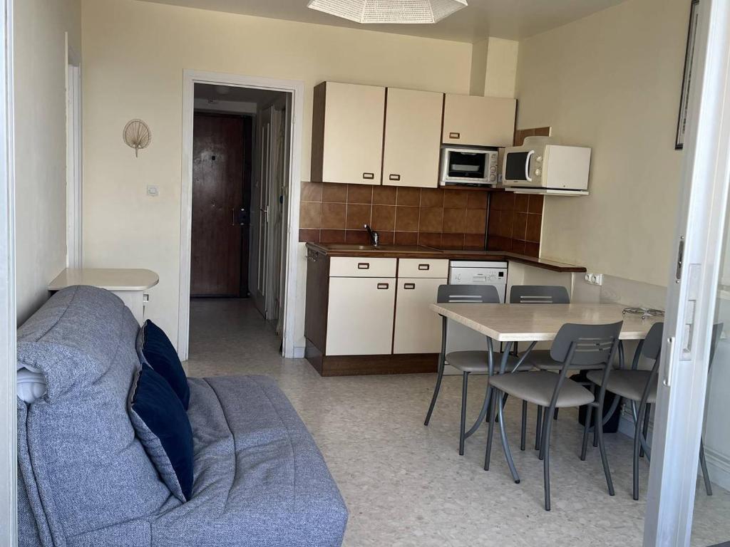 une cuisine avec un canapé et une table avec des chaises dans l'établissement APPARTEMENT CENTRE VILLE T2 - 4 PERSONNES AVEC VUE SUR MER, GARAGE ET LOGGIA, à La Grande Motte