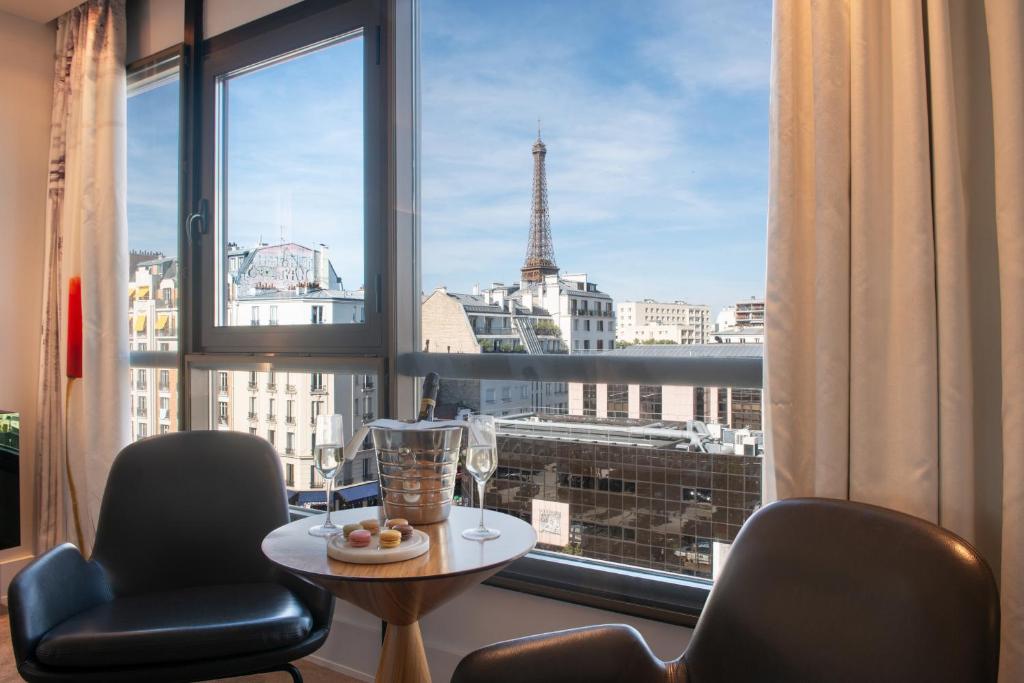 um quarto com uma janela com vista para a torre Eiffel em Le Parisis - Paris Tour Eiffel em Paris