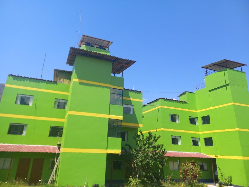 a green building with two towers on top of it at Hotel COMTUCAR in Carhuaz