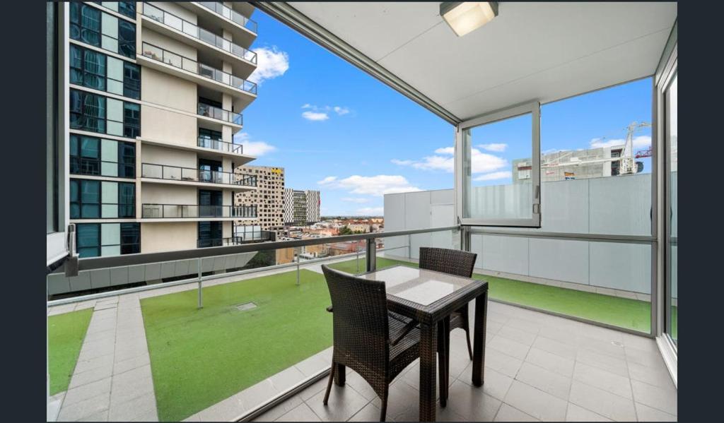 un balcone con tavolo e sedie in cima a un edificio di Hi 5 star Adelaide City Luxury Oasis a Adelaide