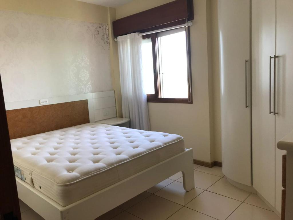 a small bedroom with a bed and a window at Vista Inacreditável Por do SOL in Tramandaí