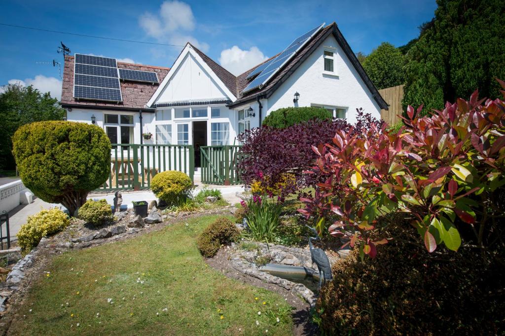 ein weißes Haus mit Sonnenkollektoren auf dem Dach in der Unterkunft Family Beach House 200m to Sea 10min to Centre in Pembrokeshire
