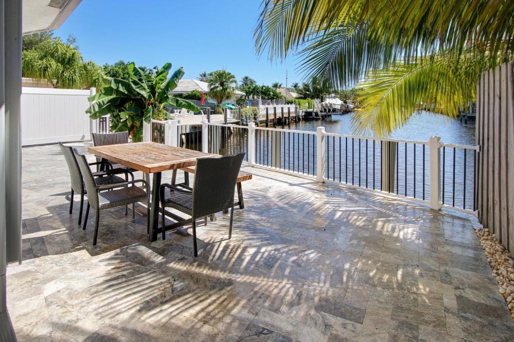 eine Terrasse mit einem Tisch, Stühlen und einem Fluss in der Unterkunft The Waterman's Retreat- 3 bedroom waterfront unit in Fort Lauderdale