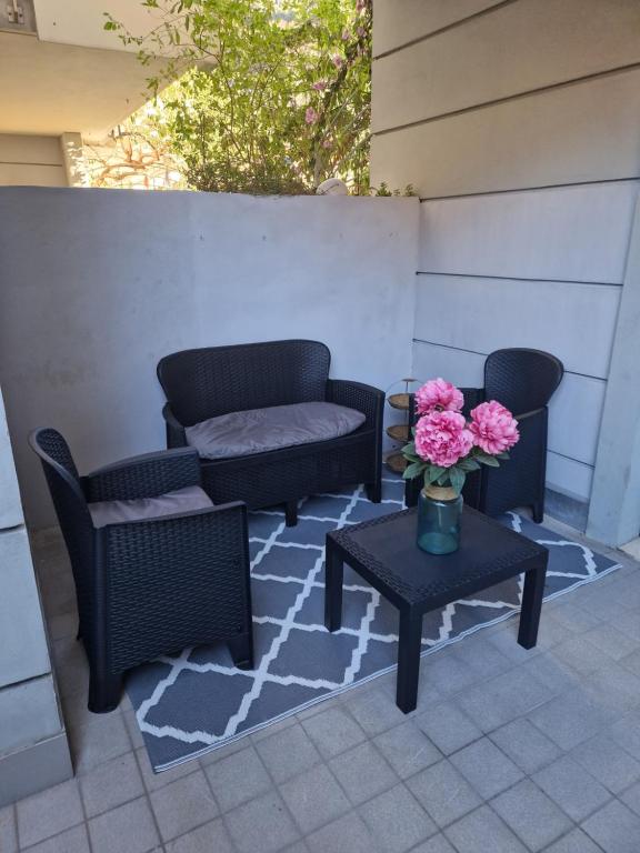 two chairs and a table with flowers on a patio at Garden & Pool Perugini in Nago-Torbole