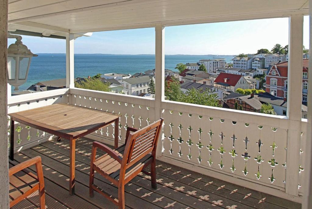 a porch with a table and chairs and a view of the ocean at Appartementhaus, Villa Katharina, Sassnitz in Sassnitz