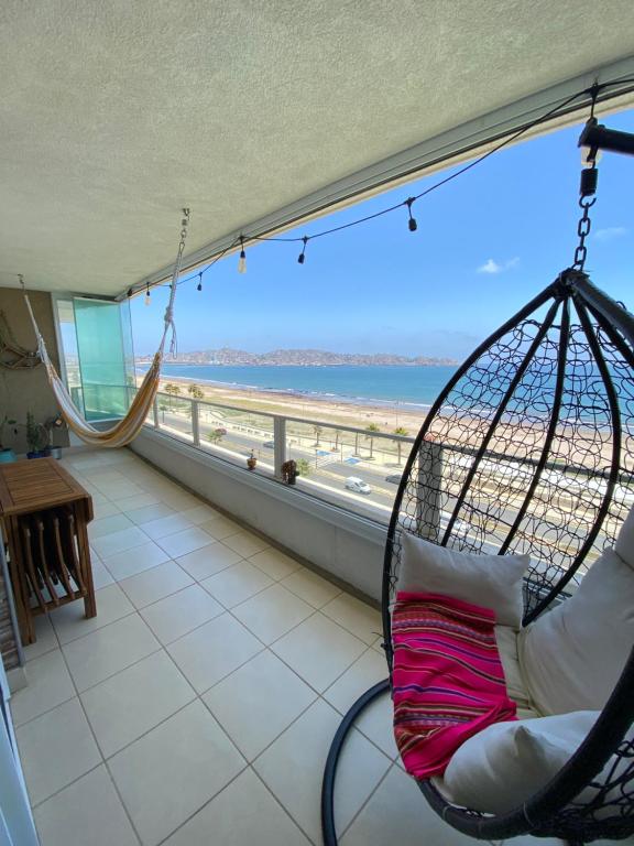 a swing in a room with a view of the beach at Departamento frente al mar full equipado in Coquimbo
