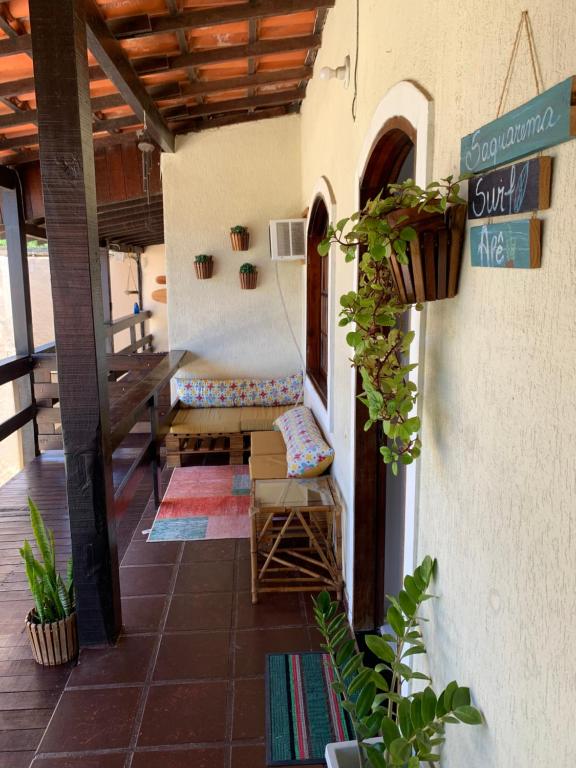 une terrasse couverte d'une maison avec un banc et des plantes dans l'établissement Saquarema Surf Apê, à Saquarema