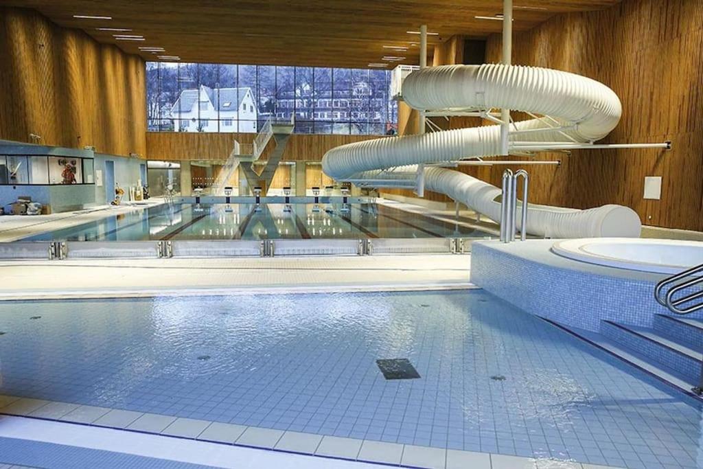 een groot zwembad met een glijbaan bij Charming house in Ulsteinvik with free parking in Ulsteinvik