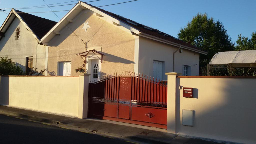 una casa con una puerta roja delante de ella en Chambres & Table d'hôtes La Bordelaise en Cenon