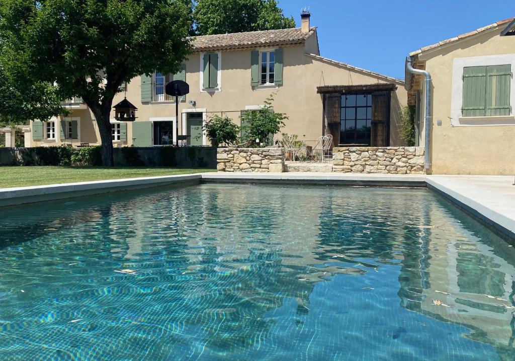 a swimming pool in front of a house at Charming Farmhouse in Provence in Cavaillon
