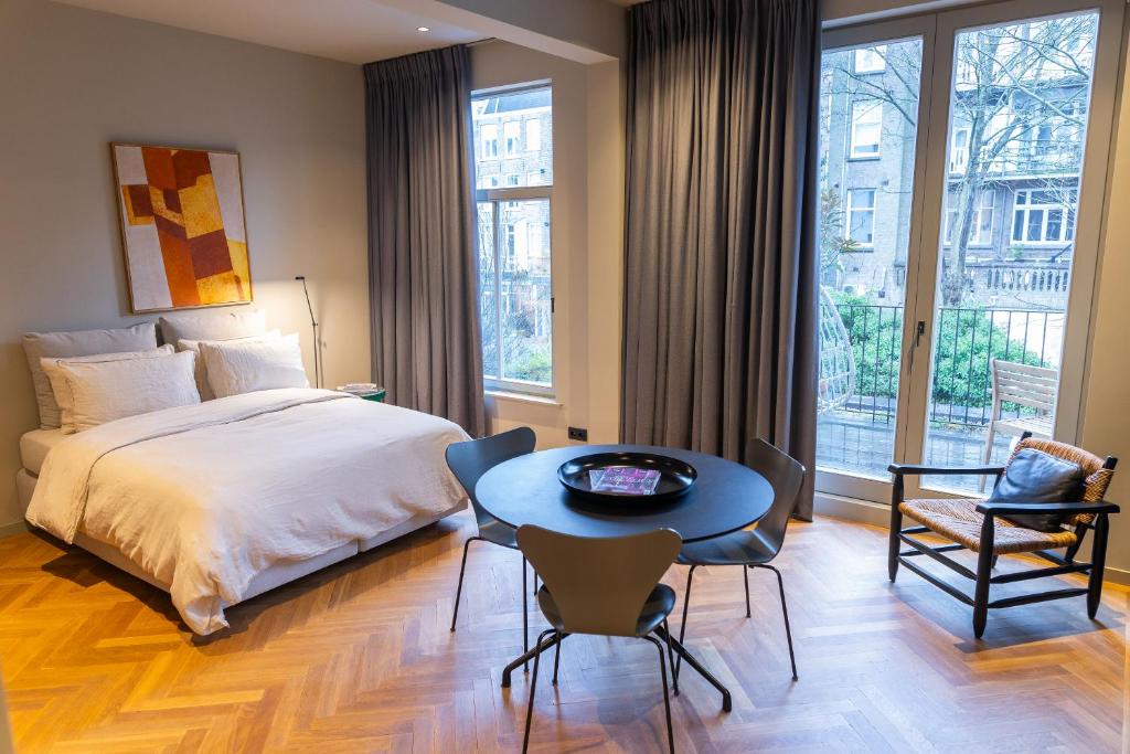 sypialnia z łóżkiem, stołem i krzesłami w obiekcie Vondel 99 w Amsterdamie