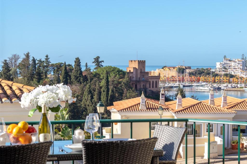 einen Balkon mit einem Tisch und Stühlen sowie Hafenblick in der Unterkunft Townhouse nº30 with fantastic sea views in Ferragudo