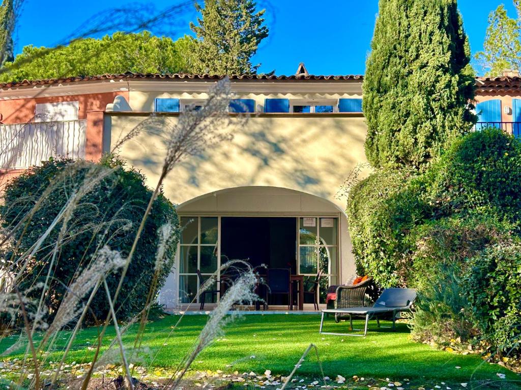 une maison avec un banc dans la cour dans l'établissement Les Restanques 21 pins 7pers, à Grimaud