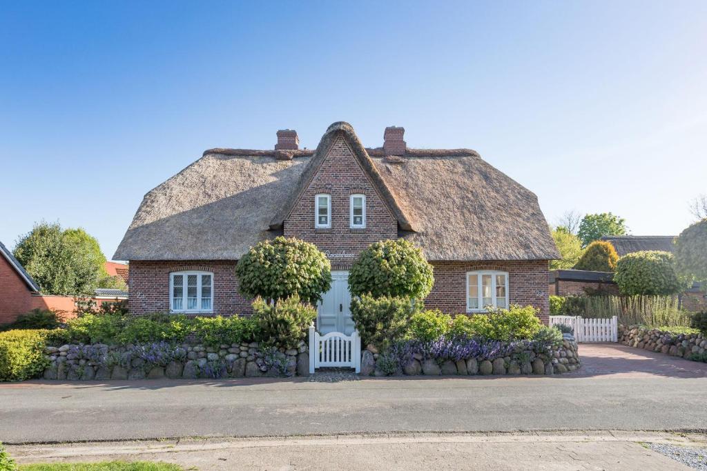 a large brick house with a thatched roof at Reethüs Brodersen in Risum-Lindholm