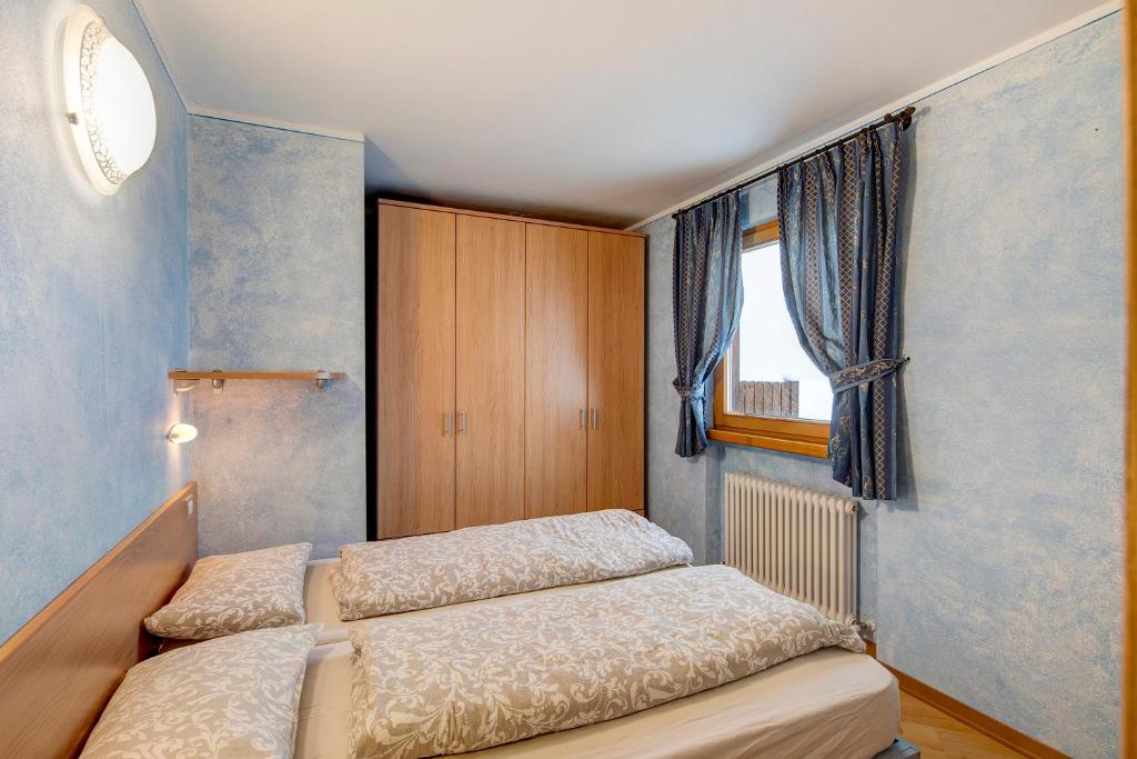 una camera con due letti e una finestra di Appartamento Piz Filone a Livigno