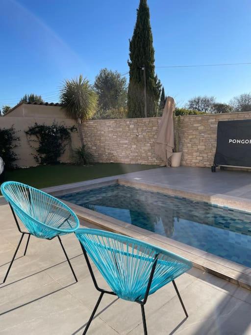 une chaise bleue assise à côté d'une piscine dans l'établissement L'Artiste - Villa 5 min du centre historique d'Aix, à Aix-en-Provence