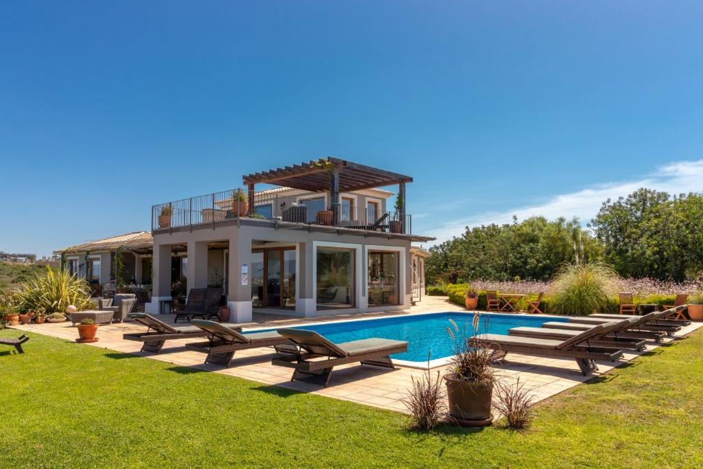 une villa avec une piscine et une maison dans l'établissement Quinta dos Caneiros Luxury villa Ocean views walk to beach, à Ferragudo