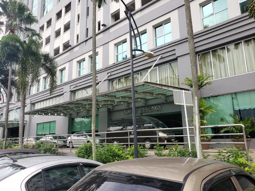 a building with cars parked in front of it at The Mons inside Tower Regency Hotel and Apartments in Ipoh