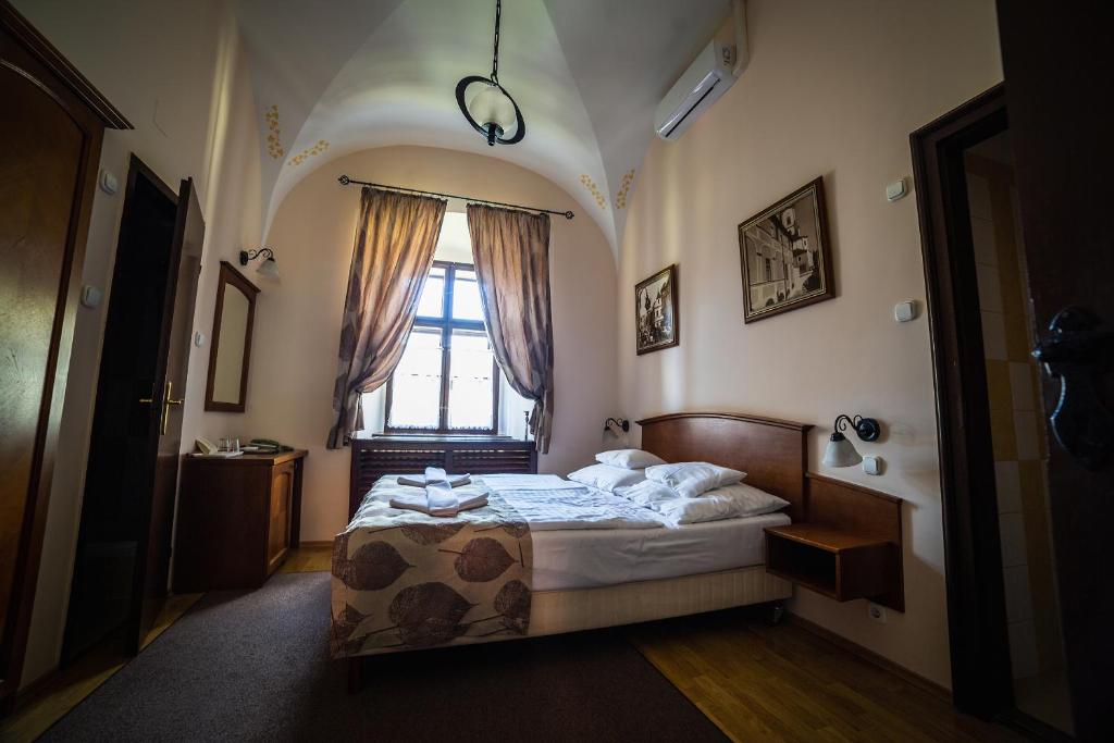 a bedroom with a bed and a window at Hotel Klastrom in Győr