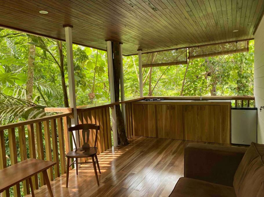 a wooden porch with a chair and a couch at NEW Jungle Casita- Steps away from Punta Uva in Punta Uva