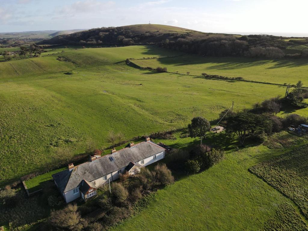an aerial view of a house in a green field at Old Coastguards - Stunning Historic Cottage in Totland