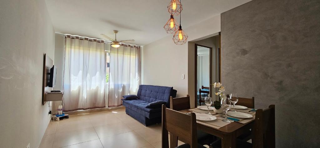 uma sala de estar com uma mesa e um sofá azul em Elegância Urbana, Apartamento Exclusivo, com ar em Maringá