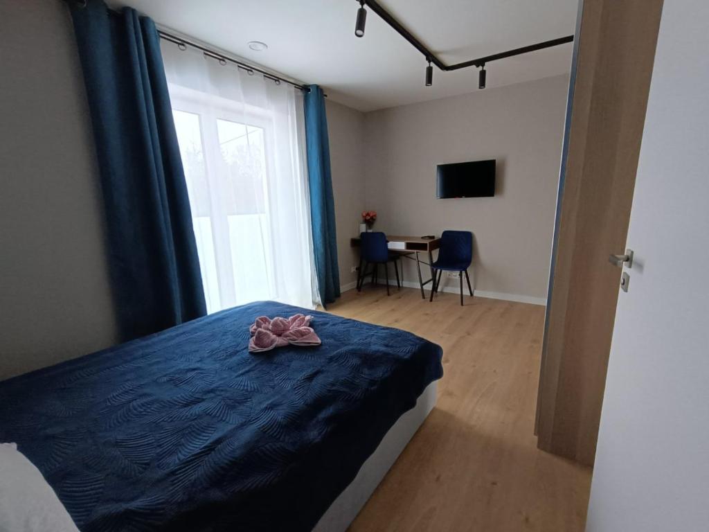 Un dormitorio con una cama con una cinta rosa. en BMH Apartments Rzeszów, en Rzeszów