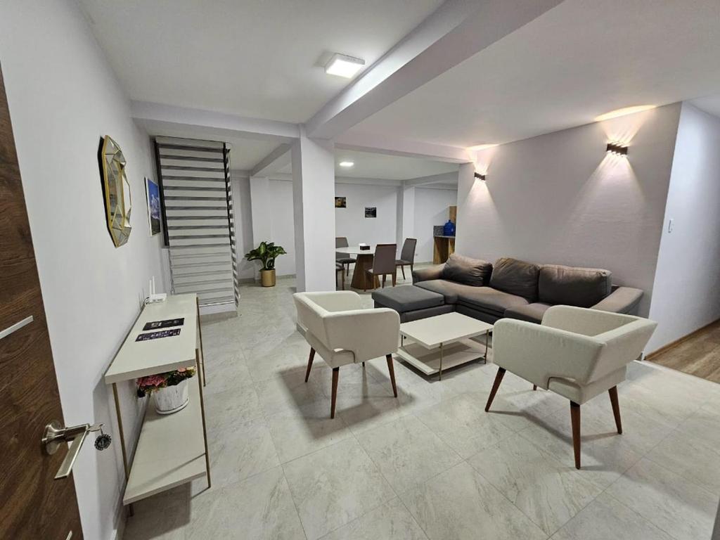 里奧班巴的住宿－New Dawn Rio，客厅配有沙发、椅子和桌子