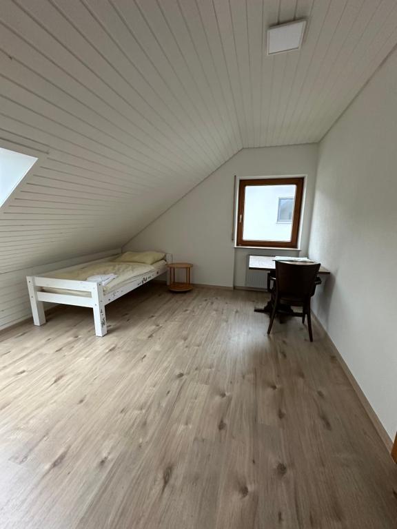 KönigsbronnにあるRuhige 4 Zimmer OG-Wohnung Z2のベッド1台、デスクが備わる屋根裏部屋