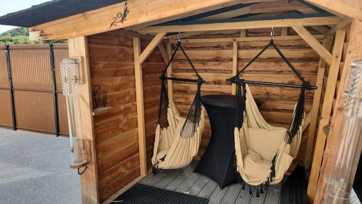 a porch with two hammocks in a shed at le chalet 