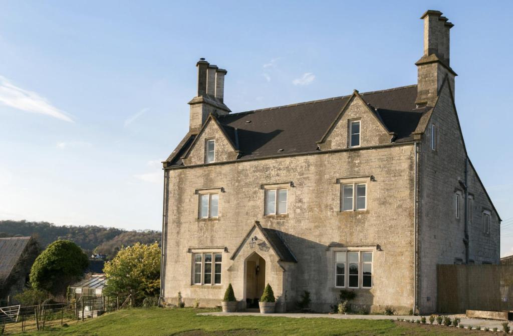 an old stone house with two chimneys at An 8 Bed Luxury Farmhouse 