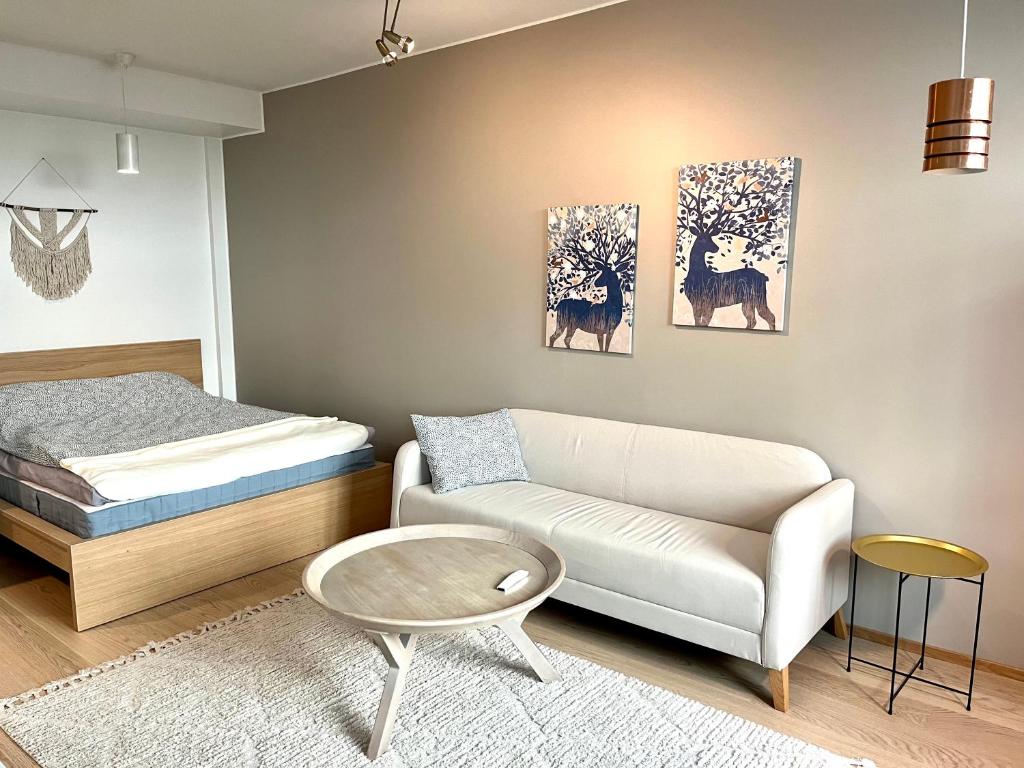 a living room with a couch and a bed at Downtown Suite in Helsinki