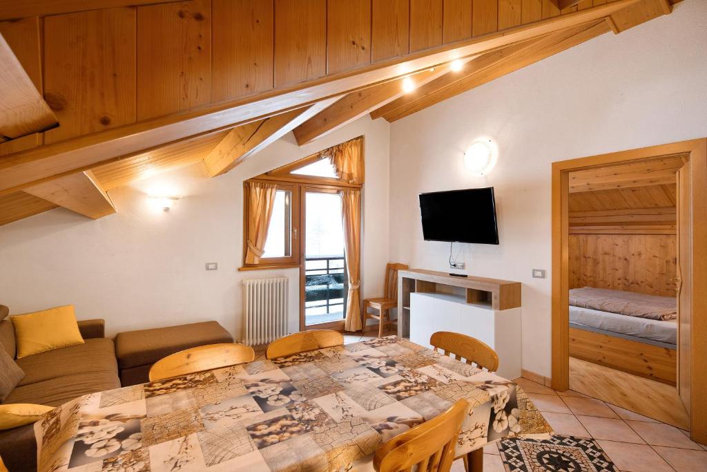 a living room with a table and a couch at Appartamento Piz Saliente in Livigno
