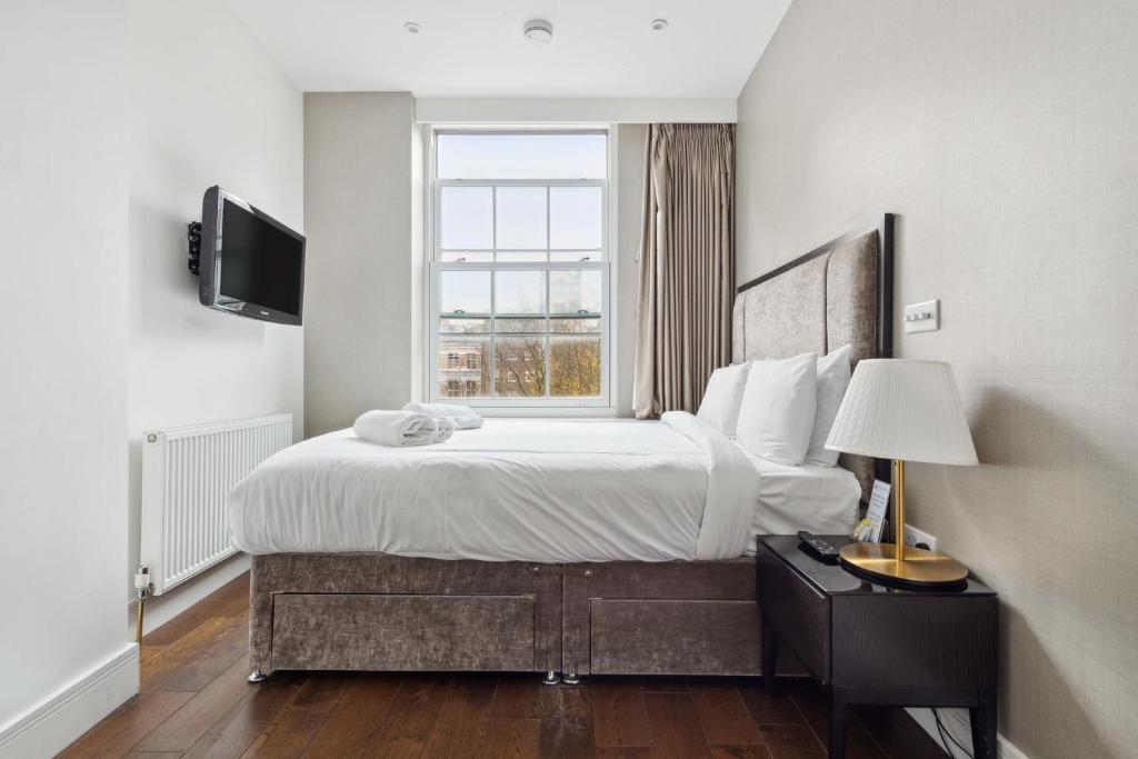 a bedroom with a large bed and a window at Golden Square in London