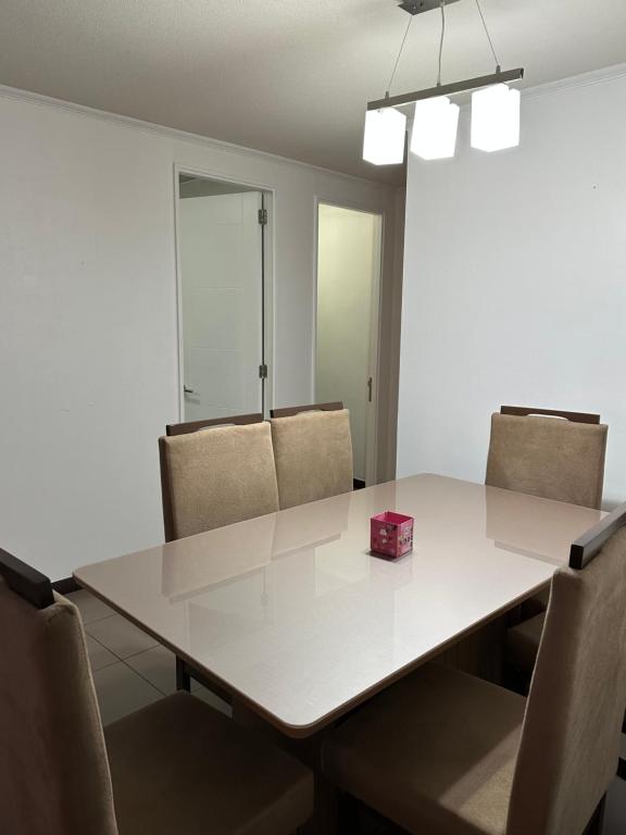 a dining room table with chairs and a pink box on it at Departamento Playa Brava 3D 2B in Iquique