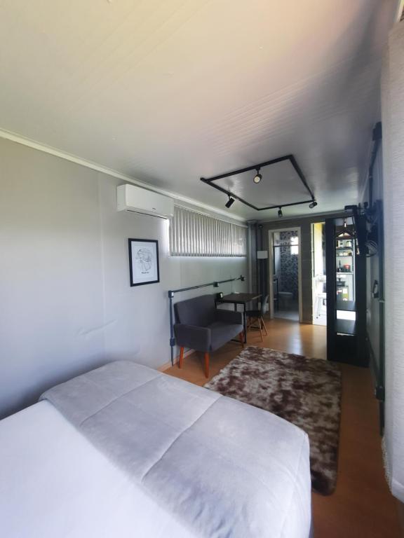 1 dormitorio con 1 cama y sala de estar con mesa en Container Guesthouse - 1 en Urubici