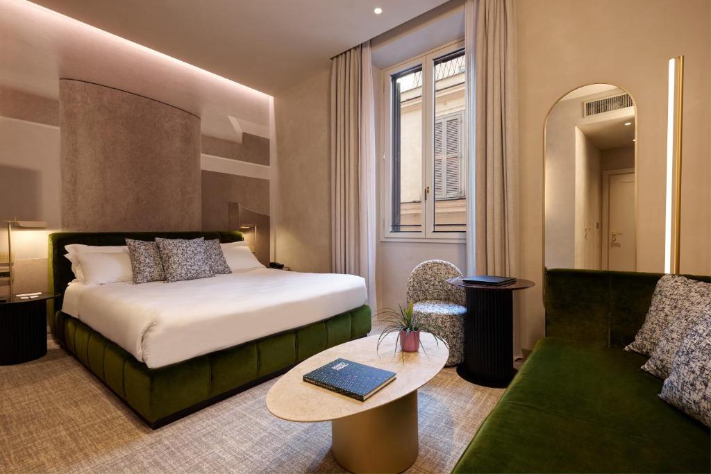 una camera d'albergo con un letto e un divano di Borghese Contemporary Hotel a Roma