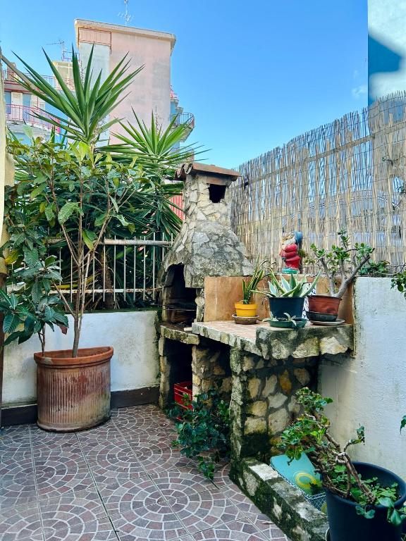 a garden with potted plants and a stone fireplace at Dea's House con parcheggio in Gaeta