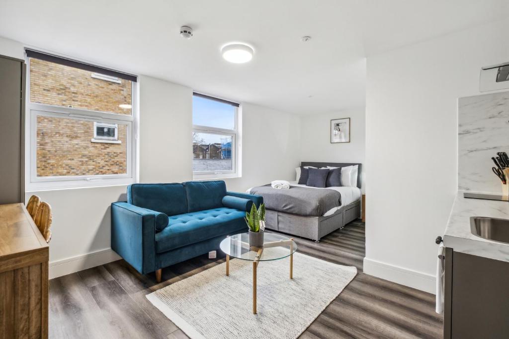 a living room with a couch and a bed at Sutherland Apartments in London