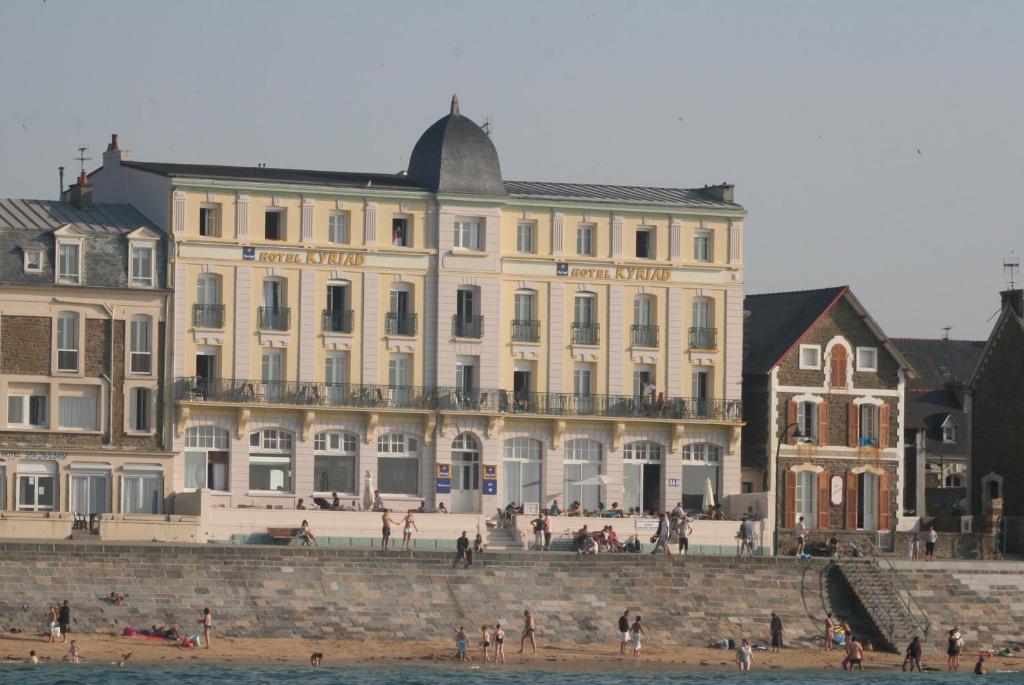 - un grand bâtiment sur la plage en face de l'eau dans l'établissement Hotel Kyriad Saint Malo Centre Plage, à Saint-Malo