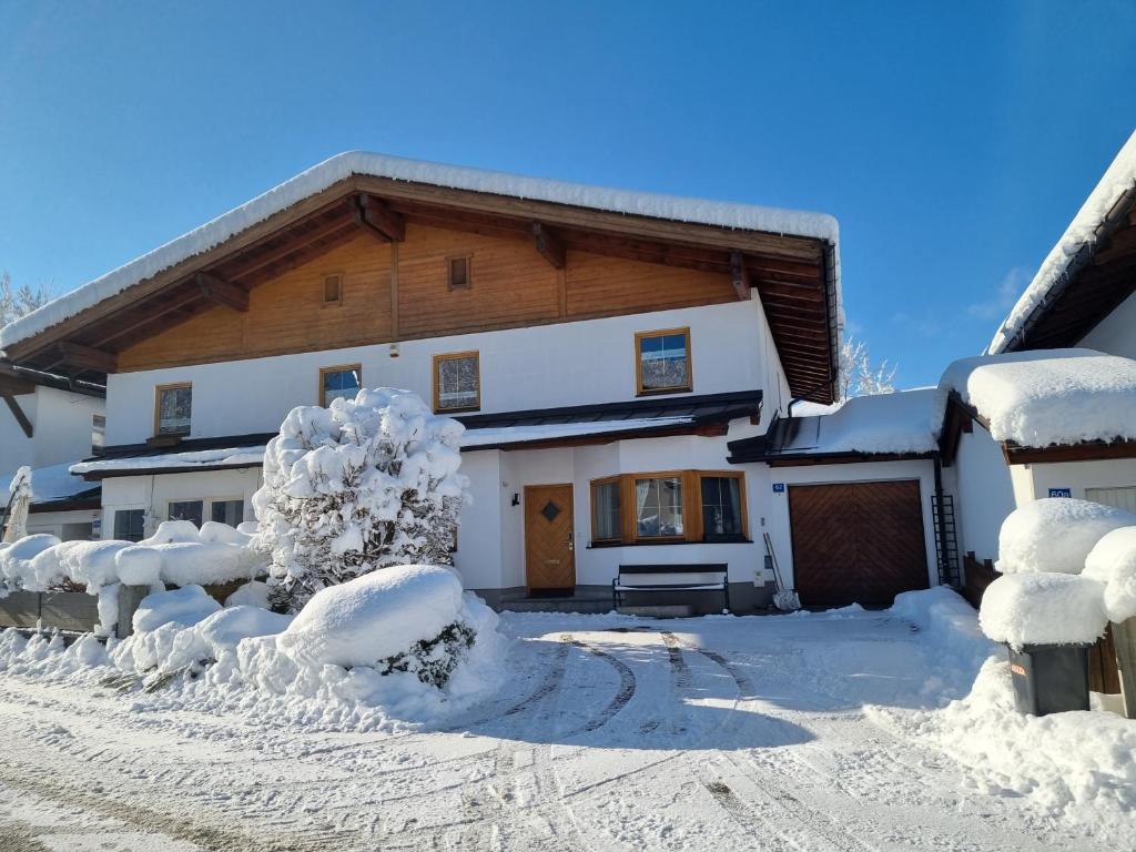 a house covered in snow in front of it at Haus Aschenwald in Kitzbühel