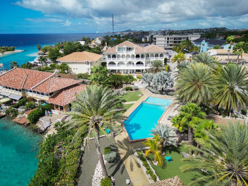 an aerial view of a resort with a pool and palm trees at Appartement Flamboyan op Ocean Resort, Mambo Curaçao in Willemstad