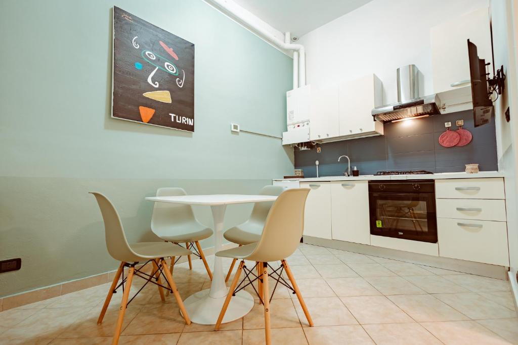 a kitchen with a table and chairs in a room at Loft Pozzo Strada in Turin