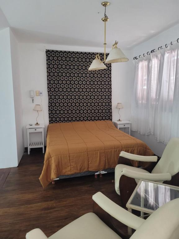 um quarto com uma cama e 2 cadeiras em Departamento A&F alquiler temporario em San Fernando del Valle de Catamarca