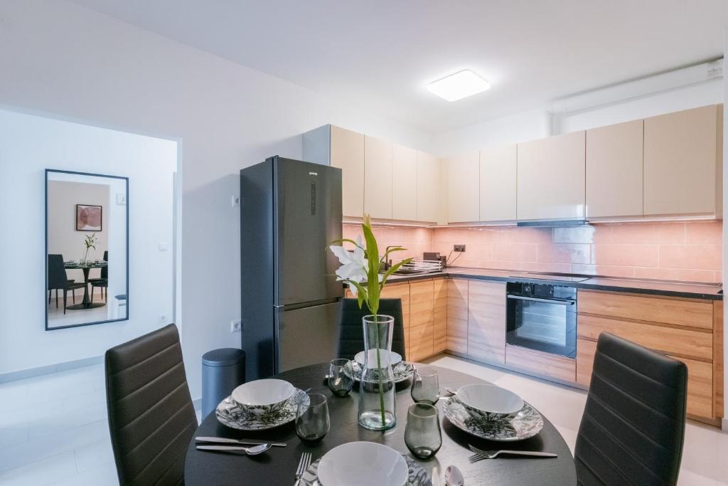 eine Küche mit einem Tisch und Stühlen sowie einem Kühlschrank in der Unterkunft Fox Premium Apartment & Free Private Parking in Budapest