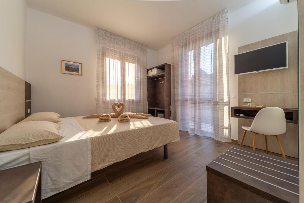 Schlafzimmer mit einem Bett, einem Schreibtisch und einem Stuhl in der Unterkunft Mentana Rooms in Parma